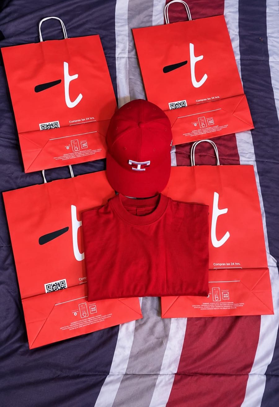 Gorra y polo rojo sobre bolsas rojas de Topitop